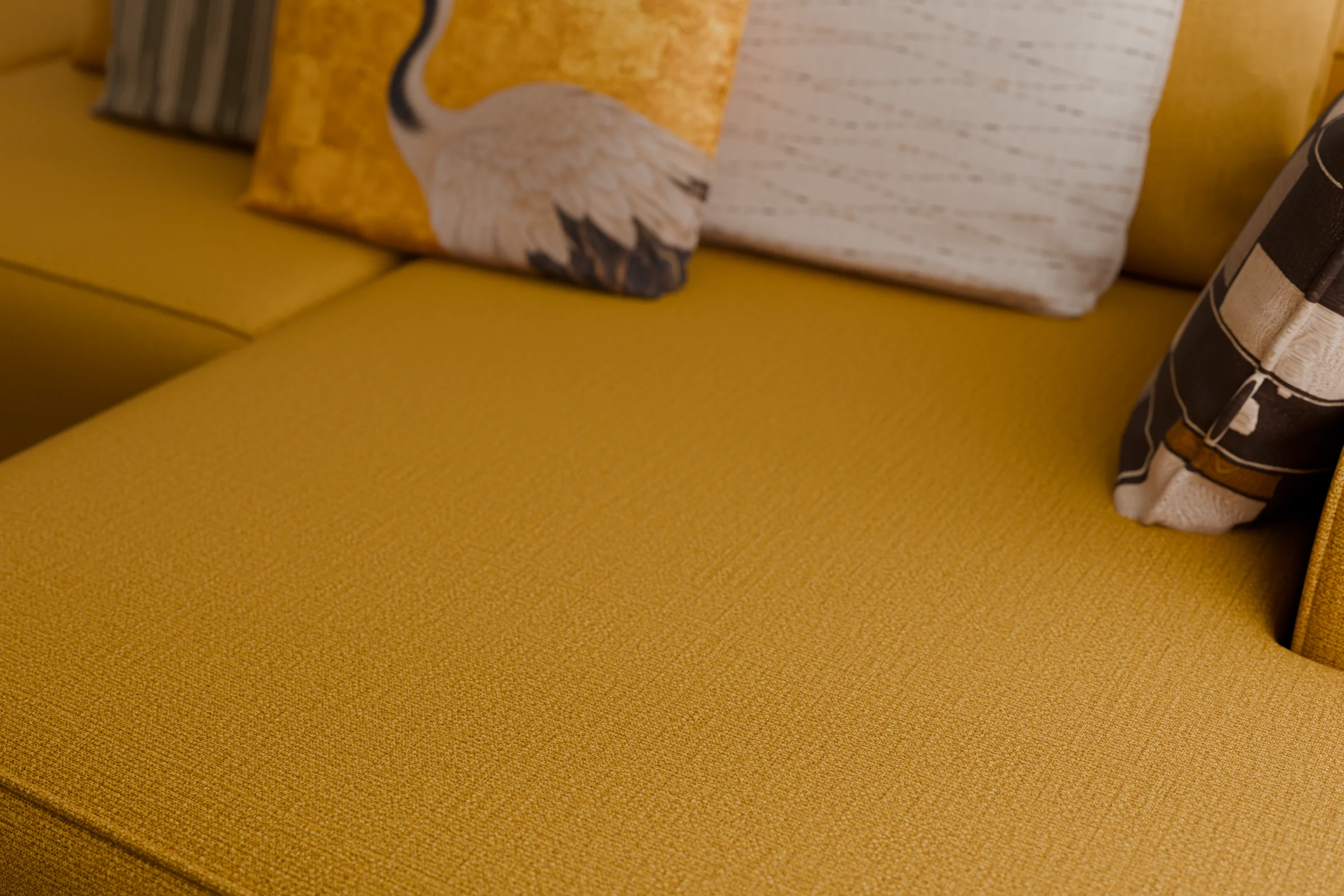 Close-up of the mustard basket-weave sofa corner